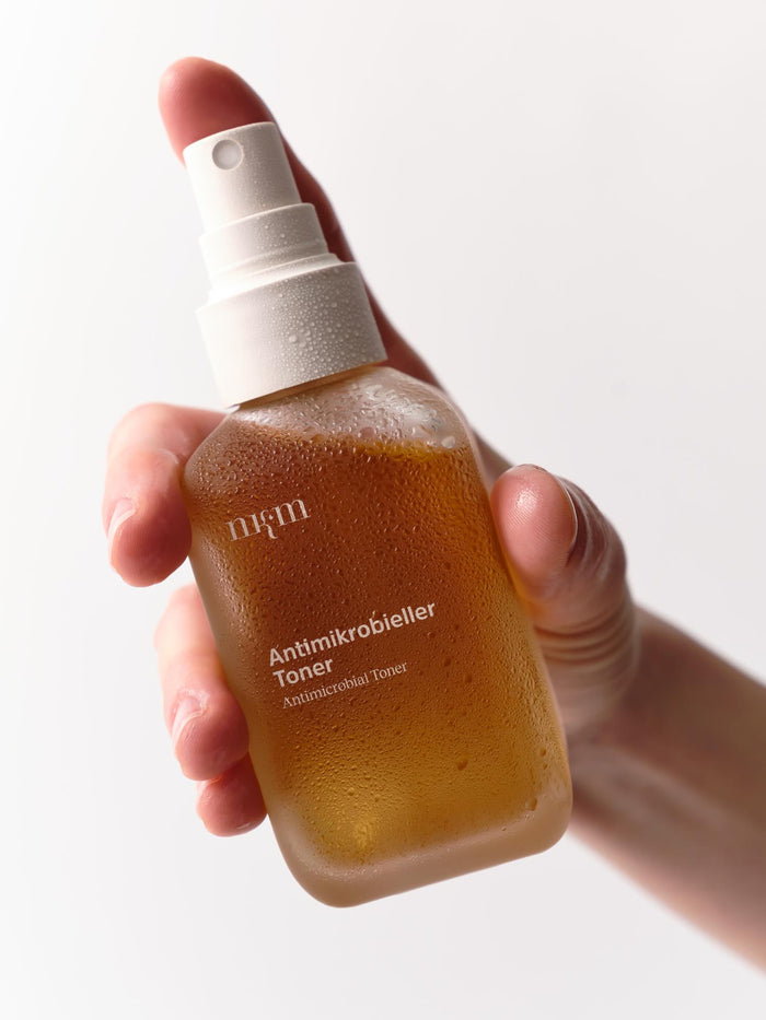 Hand hält Antimikrobiellen Toner von nkm