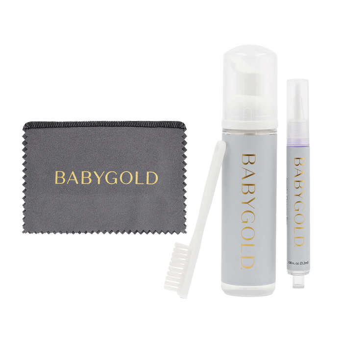 One cleaning cloth with Baby Gold in gold letters, a cleaning brush, bottle of cleaning foam with Baby Gold logo, gold cleaning pen with Baby Gold logo on transparent background.