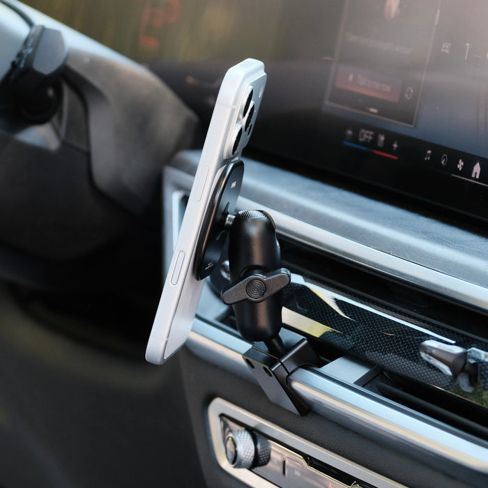 Image of Offroam MagSafe-compatible Phone Mount installed securely in BMW X5 2024-2026 | X6 2024-2027 | X7 2023-2027. This premium phone mount installs easily without drilling or glue. High force magnets hold phone on any trail, road, or track. Perfect placement without blocking screens, driver view, or air flow. Fully adjustable positioning.