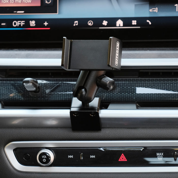 Image of Offroam Phone Mount installed securely in BMW X5 2024-2026 | X6 2024-2027 | X7 2023-2027. This premium phone mount installs easily without drilling or glue. Spring loaded Universal holder for use with any phone. Perfect placement without blocking screens, driver view, or air flow. Fully adjustable positioning.