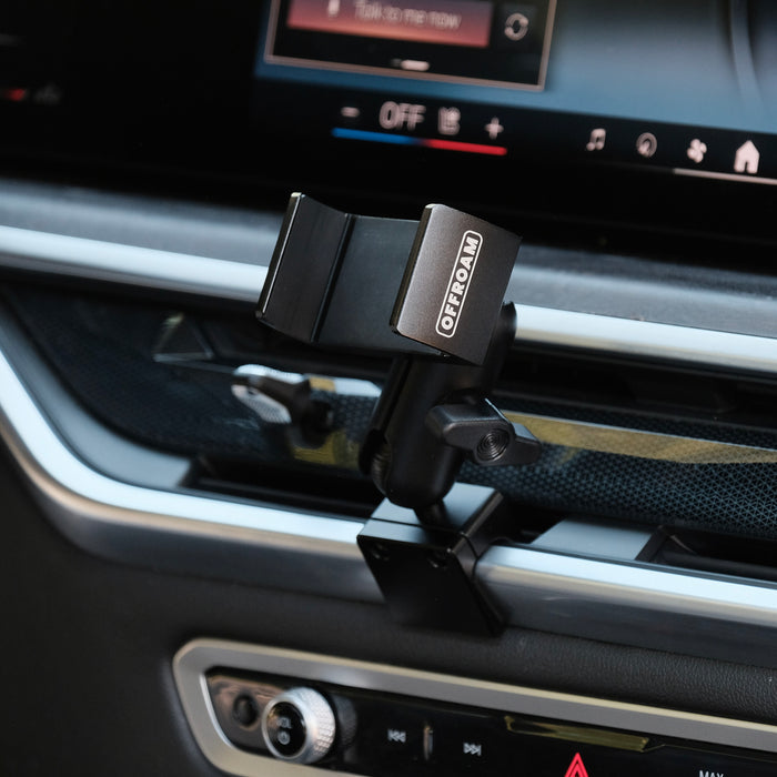 Image of Offroam Phone Mount installed securely in BMW X5 2024-2026 | X6 2024-2027 | X7 2023-2027. This premium phone mount installs easily without drilling or glue. Spring loaded Universal holder for use with any phone. Perfect placement without blocking screens, driver view, or air flow. Fully adjustable positioning.