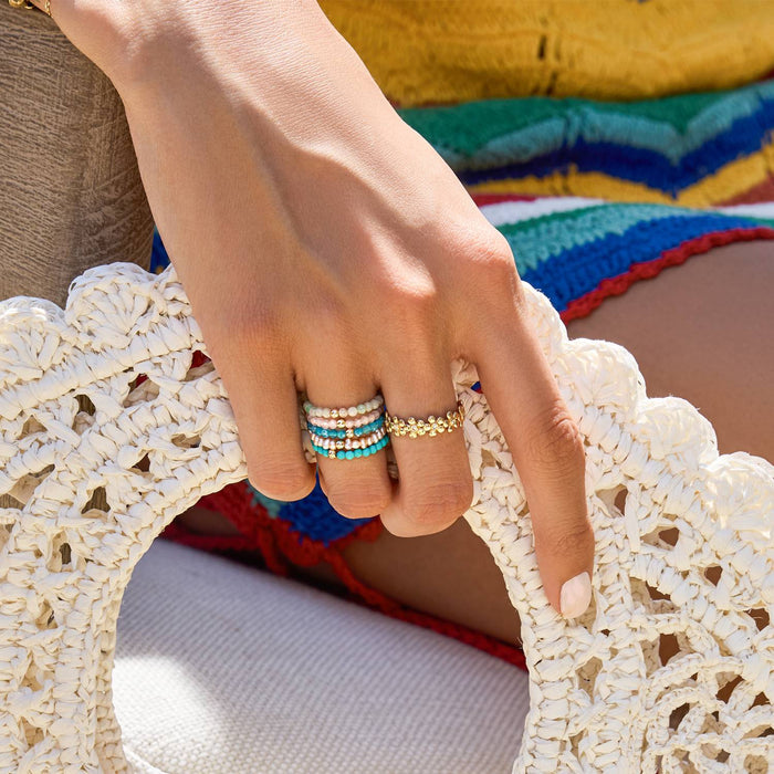 Gemstone Stretch Rings in jade, turquoise, pearl, rose quartz, apatite with 14K solid gold bead and flower ring on model.