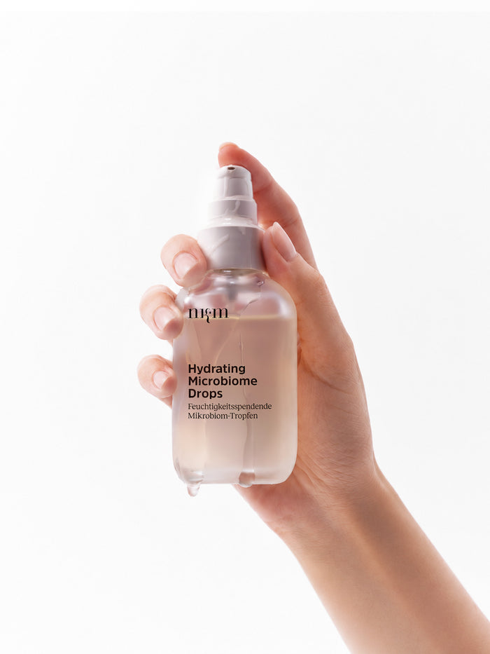 Hand hält die Hydrating Microbiome Drops von nkm