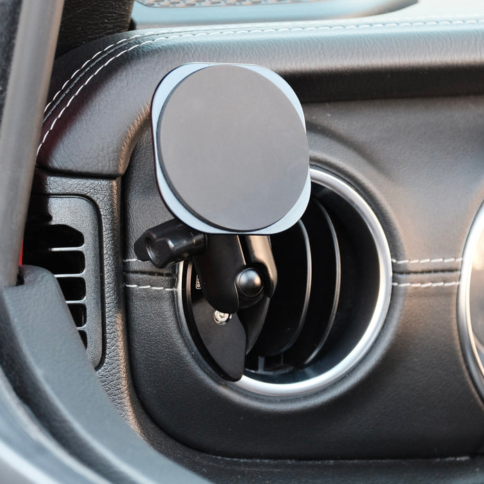 Image of Offroam MagSafe-compatible Phone Mount installed securely in Jeep Wrangler 2018-2023 | Gladiator 2019-2023. This premium phone mount installs easily without drilling or glue. High force magnets hold phone on any trail, road, or track. Perfect placement without blocking screens, driver view, or air flow. Fully adjustable positioning.