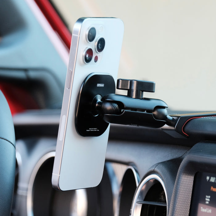 Image of Offroam MagSafe-compatible Phone Mount installed securely in Jeep Wrangler 2018-2023 | Gladiator 2019-2023. This premium phone mount installs easily without drilling or glue. High force magnets hold phone on any trail, road, or track. Perfect placement without blocking screens, driver view, or air flow. Fully adjustable positioning.