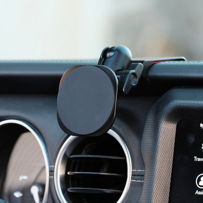 Image of Offroam MagSafe-compatible Phone Mount installed securely in Jeep Wrangler 2018-2023 | Gladiator 2019-2023. This premium phone mount installs easily without drilling or glue. High force magnets hold phone on any trail, road, or track. Perfect placement without blocking screens, driver view, or air flow. Fully adjustable positioning.