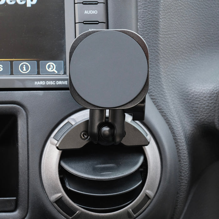 Offroam non-charging MagSafe compatible mount shown installed in Jeep Wrangler JK 2011-2018 air vent bezel without blocking air flow while holding iPhone with MagSafe securely due to strong magnets.