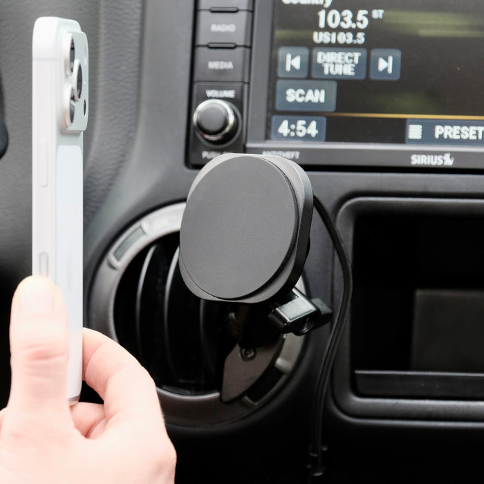 Offroam Qi2 charging mount shown installed in Jeep Wrangler JK 2011-2018 air vent bezel without blocking air flow while holding iPhone with MagSafe securely.