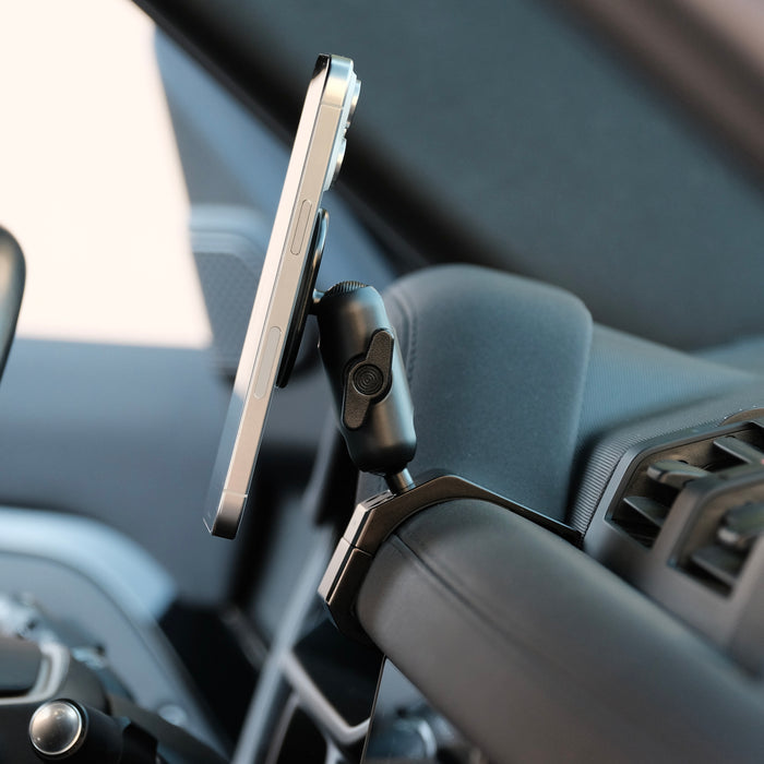 Image of Offroam MagSafe-compatible Phone Mount installed securely in Land Rover Defender 2020-2026. This premium phone mount installs easily without drilling or glue. High force magnets hold phone on any trail, road, or track. Perfect placement without blocking screens, driver view, or air flow. Fully adjustable positioning.