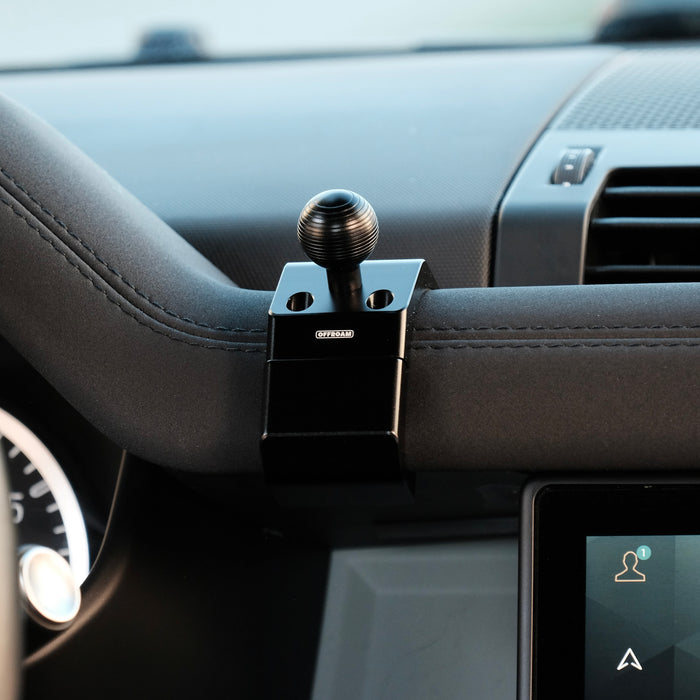 Image of Offroam Mounting Base installed securely in Land Rover Defender 2020-2026. This premium all metal phone mounting base installs easily without drilling or glue. Perfect placement without blocking screens, driver view, or air flow.
