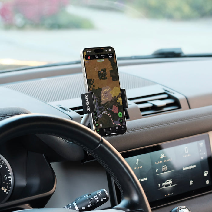Image of Offroam Phone Mount installed securely in Land Rover Defender 2020-2026. This premium phone mount installs easily without drilling or glue. Spring loaded Universal holder for use with any phone. Perfect placement without blocking screens, driver view, or air flow. Fully adjustable positioning.