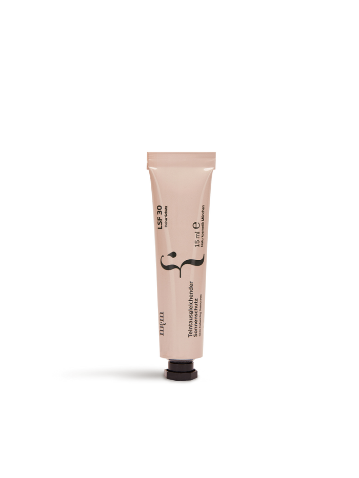 Eine beige Tube "Reisegröße Teintausgleichender Sonnenschutz Neu" von nkm Naturkosmetik München GmbH mit schwarzem Deckel, LSF30 und Zink-Beschriftung steht aufrecht vor weißem Hintergrund.
