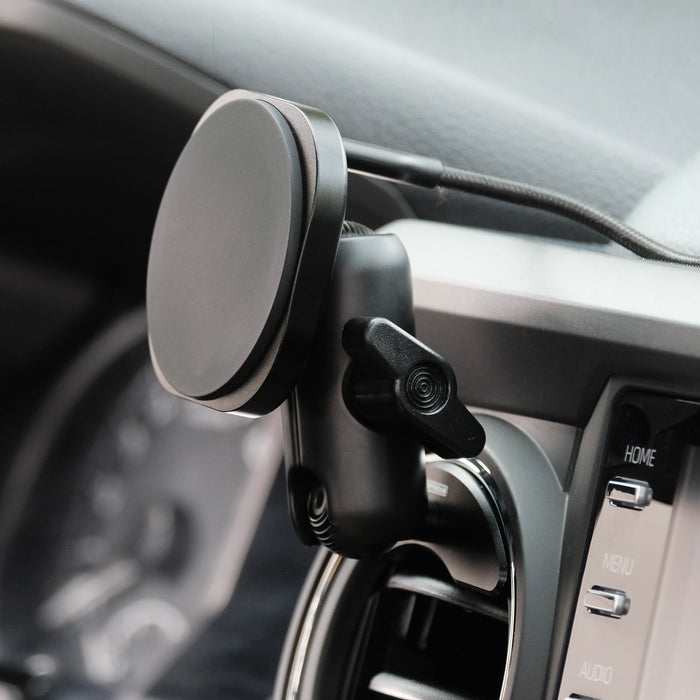 Offroam phone mount installed securely in a Toyota Tacoma 2016 to 2023 or Toyota tundra 2014 to 2021 model years. Showing vehicle specific mounting base with 20 mm ball, a coupling arm and a G2 charging holder with the cable exiting on the rear for clean cable management secure MagSafe compatible magnets inside.